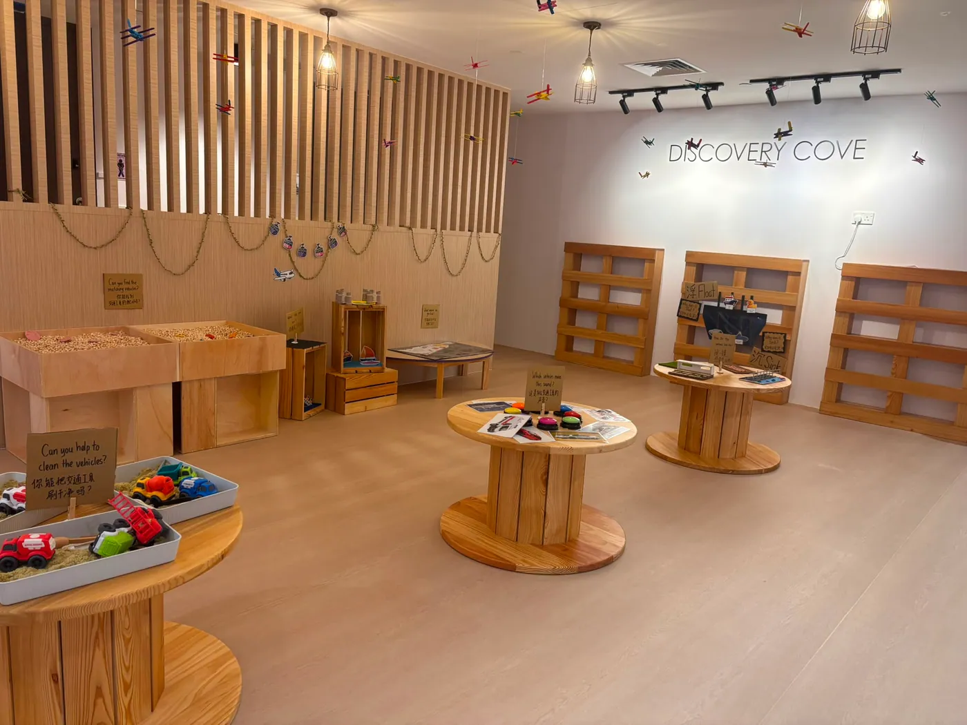 A STEM discovery room with sensory tables and hanging toy planes
