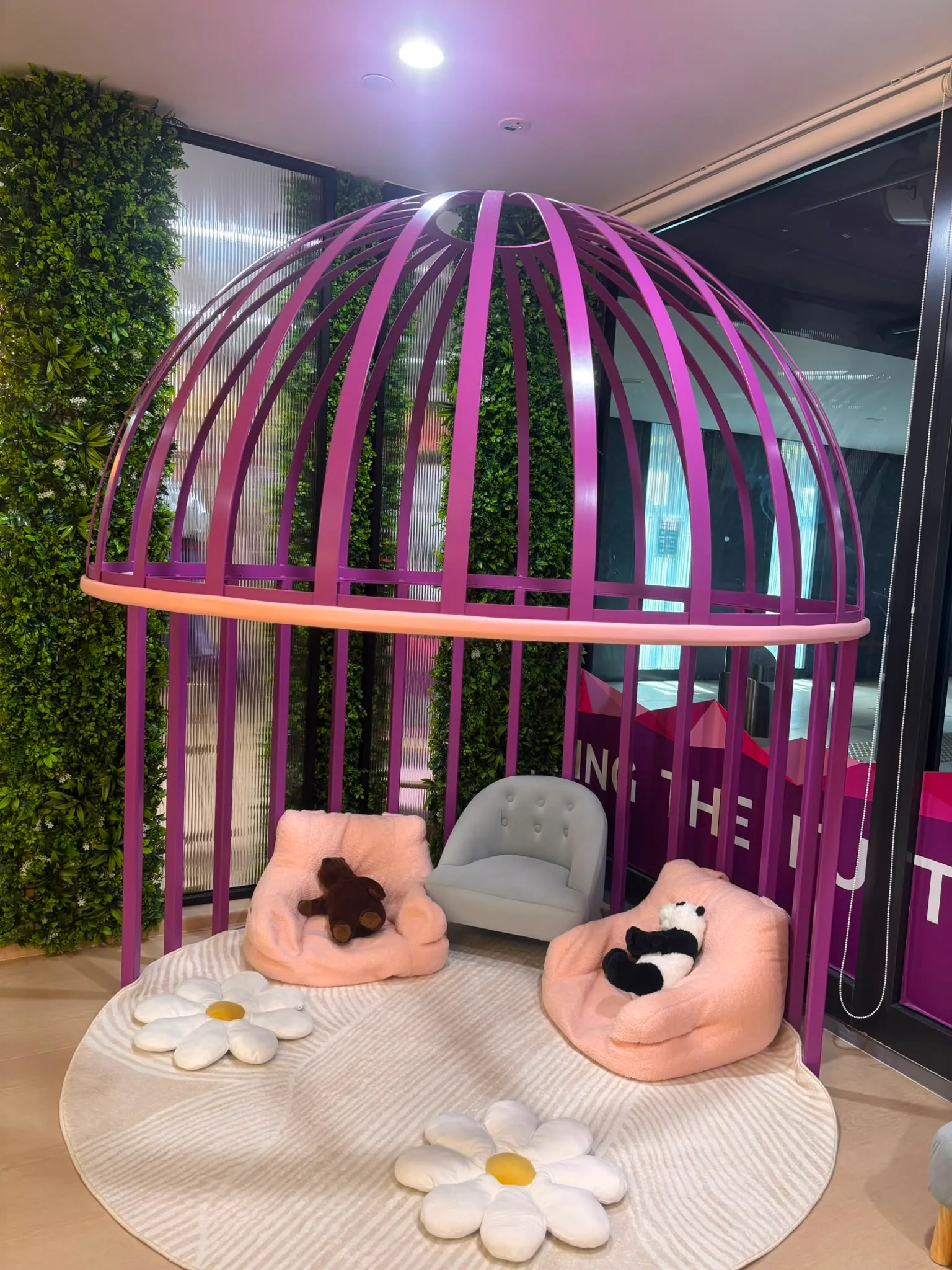 A cosy reading nook inside a purple dome with soft cushions