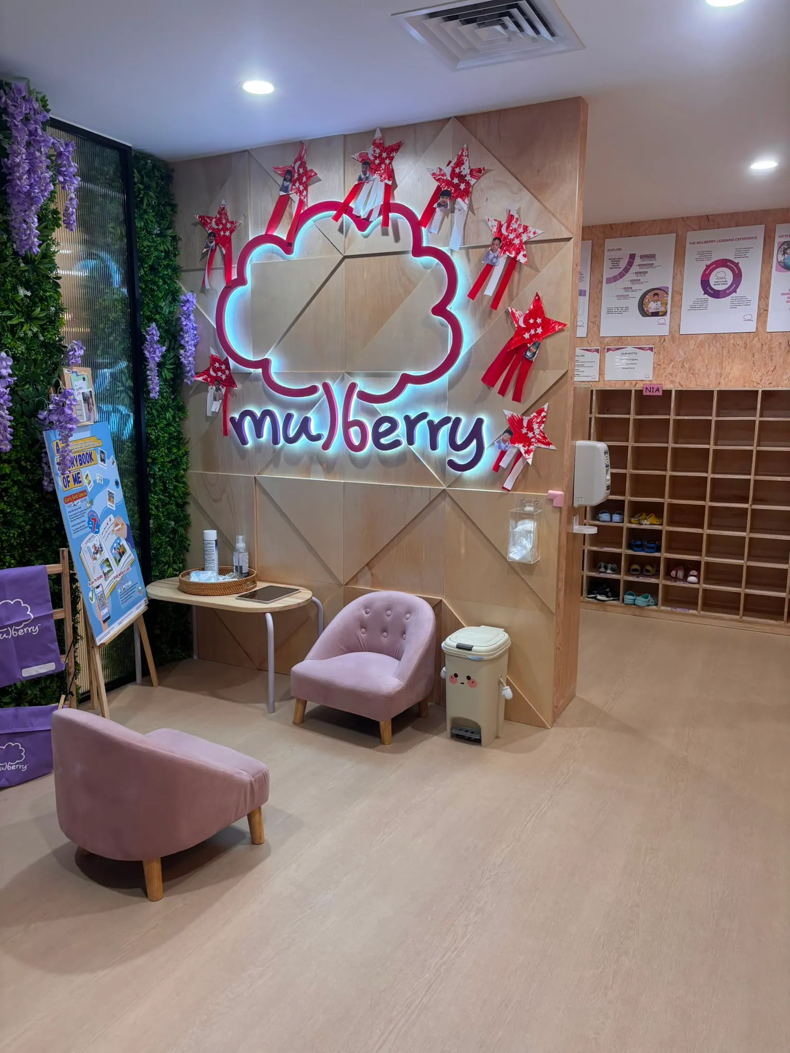 The Mulberry reception with its glowing cloud logo and lush green wall